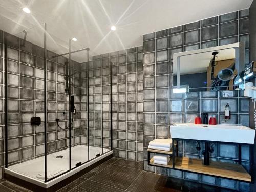 ein Badezimmer mit einer Dusche, einem Waschbecken und einer Badewanne in der Unterkunft DORMERO Hotel Reutlingen in Reutlingen