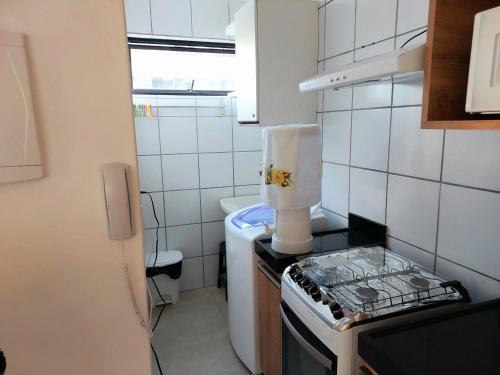 una pequeña cocina con fogones y fregadero en Apartamento Vernazza Jatiuca, en Maceió