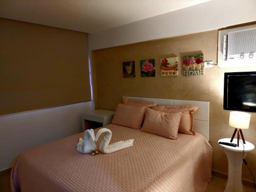 un dormitorio con una cama con un animal de peluche en Apartamento Vernazza Jatiuca, en Maceió