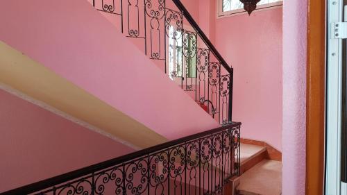 a staircase in a home with pink walls at Hôtel Restaurant BOUGAFER in Oulad Akkou
