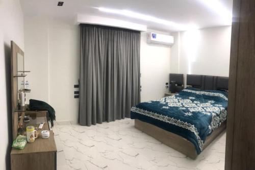 a bedroom with a bed with a blue blanket at شقة فندقية بغرفتين قرب مول مصر وميدان جهينة families only in Sheikh Zayed