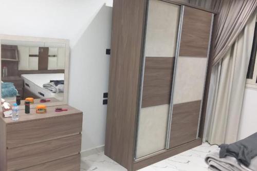 a bathroom with a wooden closet and a mirror at شقة فندقية بغرفتين قرب مول مصر وميدان جهينة families only in Sheikh Zayed