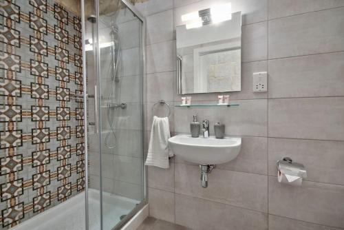 a bathroom with a sink and a shower at Vallettastay Old Lodge Apartment 4 in Valletta