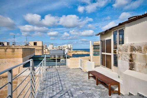 a balcony with a bench and a view of the water at Vallettastay Old Lodge Apartment 4 in Valletta