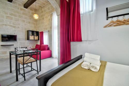 a bedroom with a bed and a table in a room at Old Lodge Studio 5 by Vallettastay in Valletta