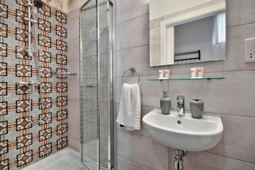 a bathroom with a sink and a shower at Vallettastay Old Lodge Studio 5 in Valletta