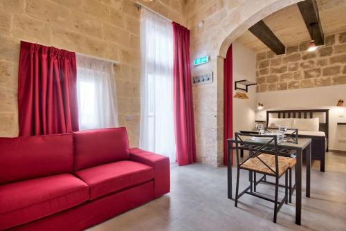 a living room with a red couch and a table at Old Lodge Studio 5 by Vallettastay in Valletta