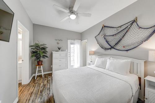 a bedroom with a bed and a ceiling fan at Beach Way Mermaid Cove in Padre Island