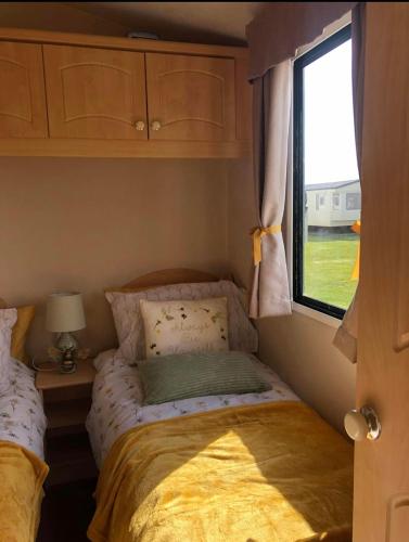 a small bedroom with a bed and a window at R&S HOLIDAY HOMES THE CHASE r14 in Skegness