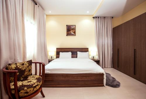 um quarto com uma cama e uma cadeira em Rushmore - Premier 2 Room em Lagos