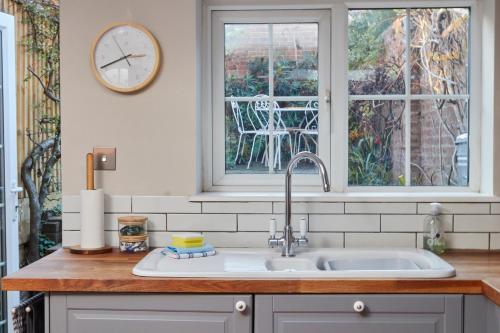 a kitchen counter with a sink and a window at Windlass Cottage in Lymington