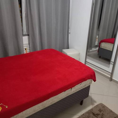 Un dormitorio con una manta roja en una cama en Luxo sala e quarto quadra da praia Copacabana, en Río de Janeiro