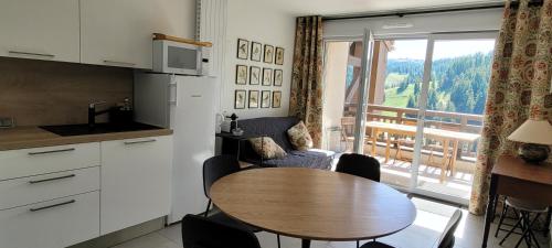 Il comprend une cuisine avec une table et un balcon. dans l'établissement Très bel appartement neuf, à Péone