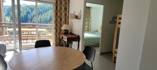 a table and chairs in a room with a bedroom at Très bel appartement neuf in Péone