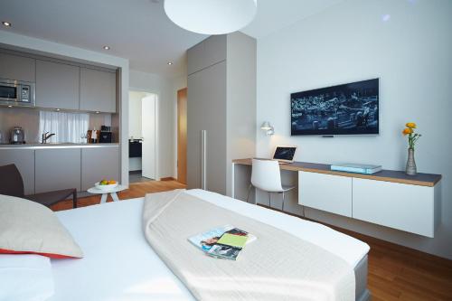 a bedroom with a bed and a desk with a laptop at ipartment Frankfurt City Centre in Frankfurt/Main