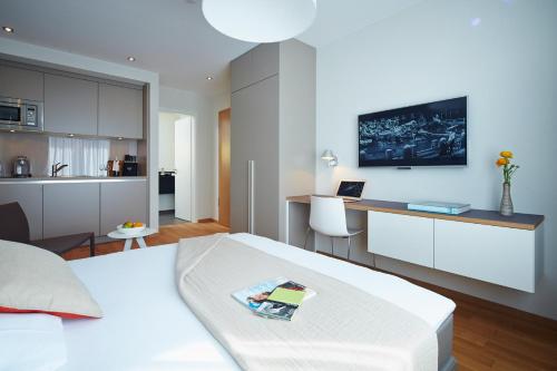 a bedroom with a bed and a desk with a laptop at ipartment Frankfurt Europaviertel in Frankfurt