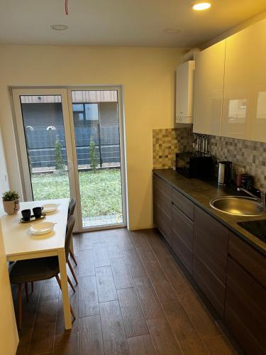 a kitchen with a table and a dining room at Izabelės apartamentai in Palanga