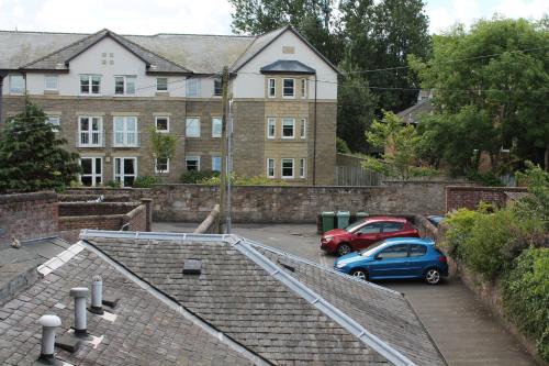 a blue car parked in a parking lot in front of a building at townhouse apartments in Ayr