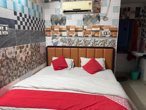 un letto con due cuscini rossi in una stanza di DKR REGENCY a Kurnool