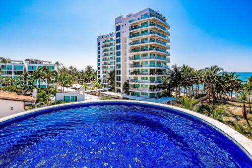 a large blue swimming pool in front of a tall building at Nitta 310 PH in Nuevo Vallarta 