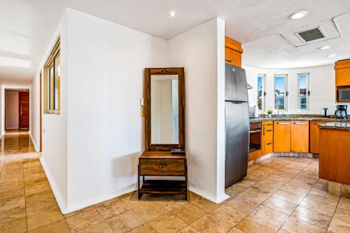 a kitchen with wooden cabinets and a stainless steel refrigerator at Nitta 310 PH in Nuevo Vallarta 