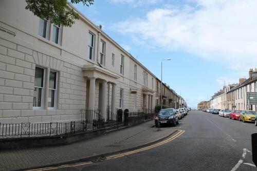 a street with cars parked on the side of a building at townhouse apartments in Ayr