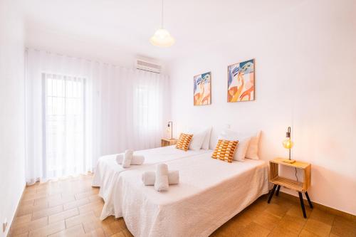 ein weißes Schlafzimmer mit einem großen Bett und einem Fenster in der Unterkunft Villa Amaris in Albufeira