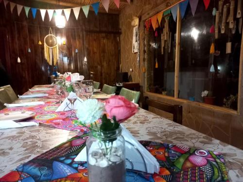 een lange tafel met een vaas met bloemen erop bij Hostal Sisabel in Tinogasta
