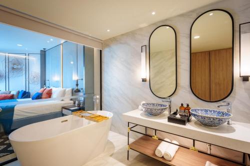 a bathroom with a tub and a bedroom with a bed at Somerset Pattaya in Pattaya Central