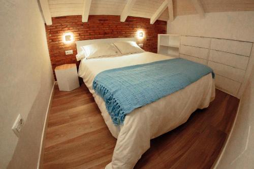 a bedroom with a large bed with a brick wall at Apartamentos Plaza de España 6 in Villanueva de la Serena