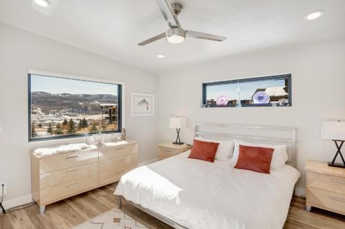 a white bedroom with a bed and two windows at Sunlight Retreat in Steamboat Springs