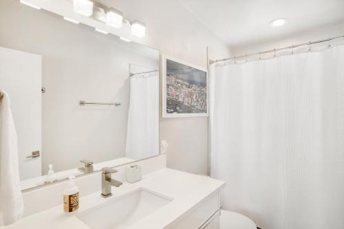 Baño blanco con lavabo y espejo en Sunlight Retreat en Steamboat Springs