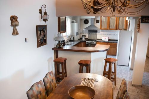 cocina con mesa de madera y nevera blanca en Departamento Las 3 Marías en San Carlos de Bariloche