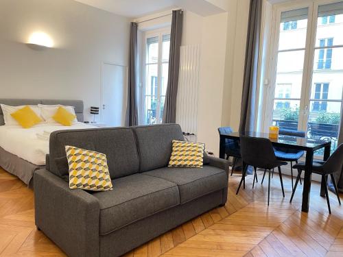 uma sala de estar com um sofá e uma mesa em Paris Square em Paris