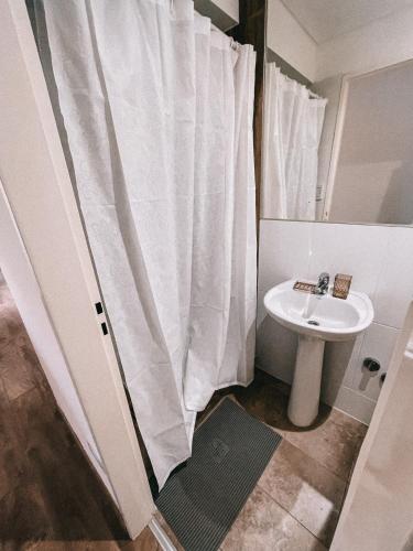 baño con cortina de ducha blanca y lavamanos en AIRES VERDES en Salta