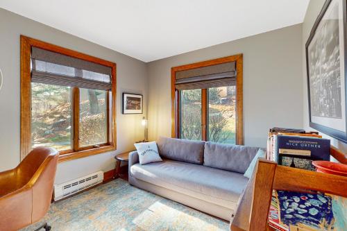 a living room with a couch and two windows at Saltbox 2A in Quechee