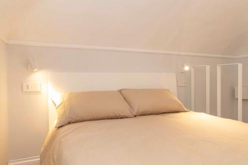 - une chambre avec un lit blanc et une tête de lit blanche dans l'établissement Loft Boutique, à Turin