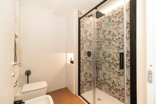 La salle de bains est pourvue de toilettes et d'une douche en verre. dans l'établissement Loft Boutique, à Turin