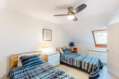 1 dormitorio con 2 camas y ventilador de techo en Saltbox 12A, en White River Junction