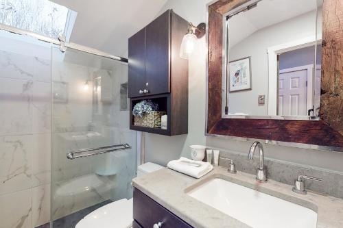 La salle de bains est pourvue d'un lavabo, de toilettes et d'un miroir. dans l'établissement Dartmouth Place Retreat, à White River Junction