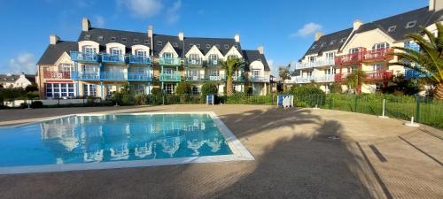 Un gran edificio con una piscina en frente. en Cap Marine 8, en Le Guilvinec