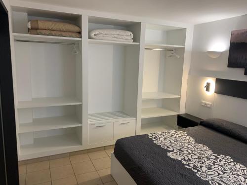 1 dormitorio con estanterías blancas y 1 cama en Pis Cala Tere, en Cadaqués