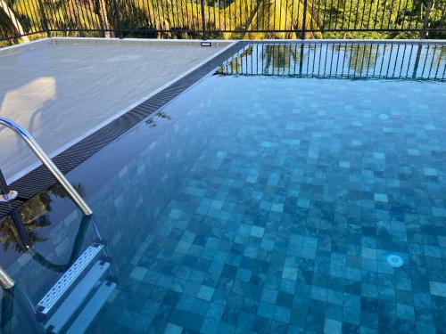 a swimming pool with blue tiles on the water at Atrium Hiriketiya in Hiriketiya