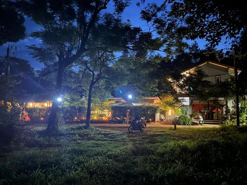 a man riding a motorcycle in a yard at night at Hanoii House in Ko Mak