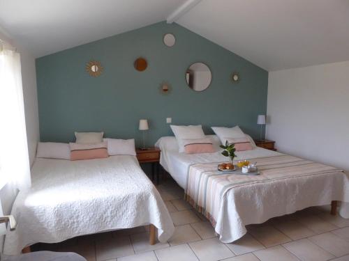 a bedroom with two beds and a green wall at Gîte du Domaine de Coutancie in Prigonrieux