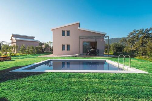 eine Villa mit einem Pool vor einem Haus in der Unterkunft Villas EPTA KARPI Complex of 7 Luxury Villas in Skriperón