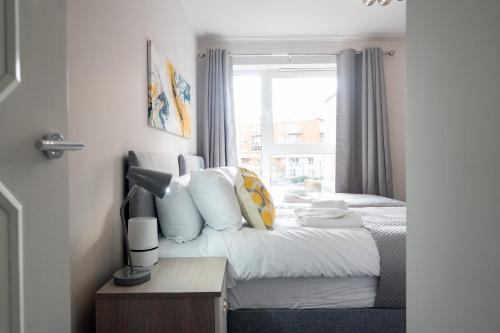a hotel room with a bed and a window at OLD LISTING Cardiff Bay, Modern Chic 2BR, Free Parking in Cardiff