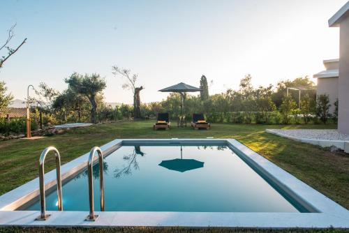 een zwembad in de achtertuin van een huis bij Villas EPTA KARPI Complex of 7 Luxury Villas in Skriperón