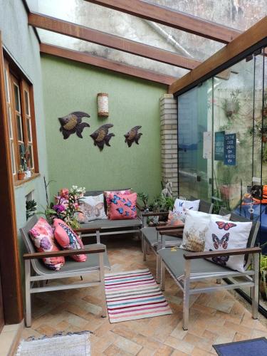 a patio with couches and pillows on a wall at Pousada Familiar Morada Lua Nova in Florianópolis