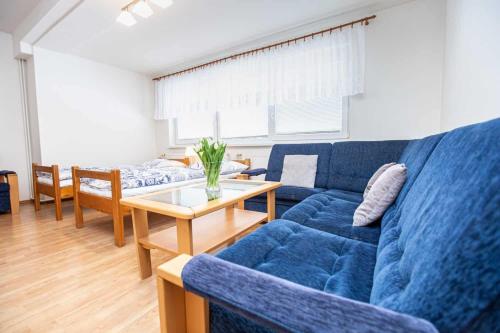 a living room with a blue couch and a table at PENZION NA VÝSLUNÍ in Nové Město nad Metují